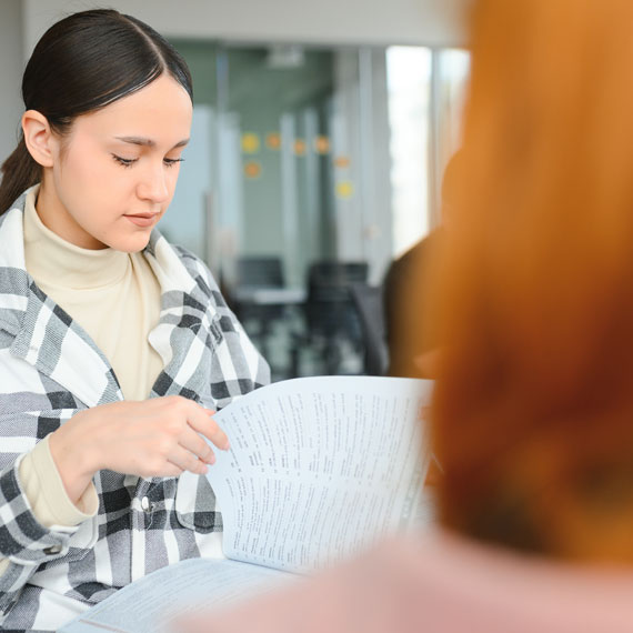 A young woman reading through a document.