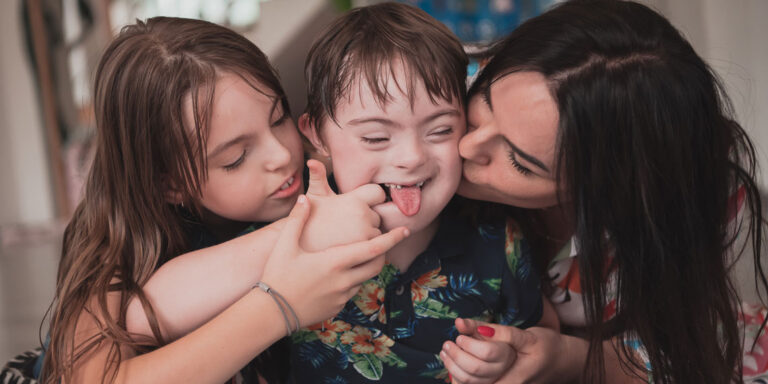 A woman and two kids showing love and joy in a warm moment together.