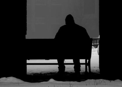 Silhouette of a person sat on a bench in the snow